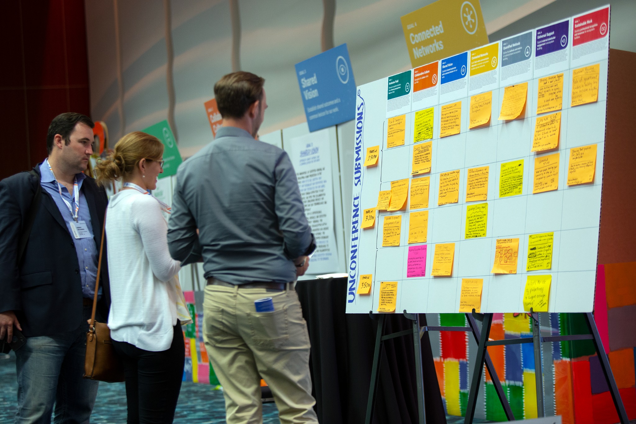 Summit participants studying a wall of shared ideas
