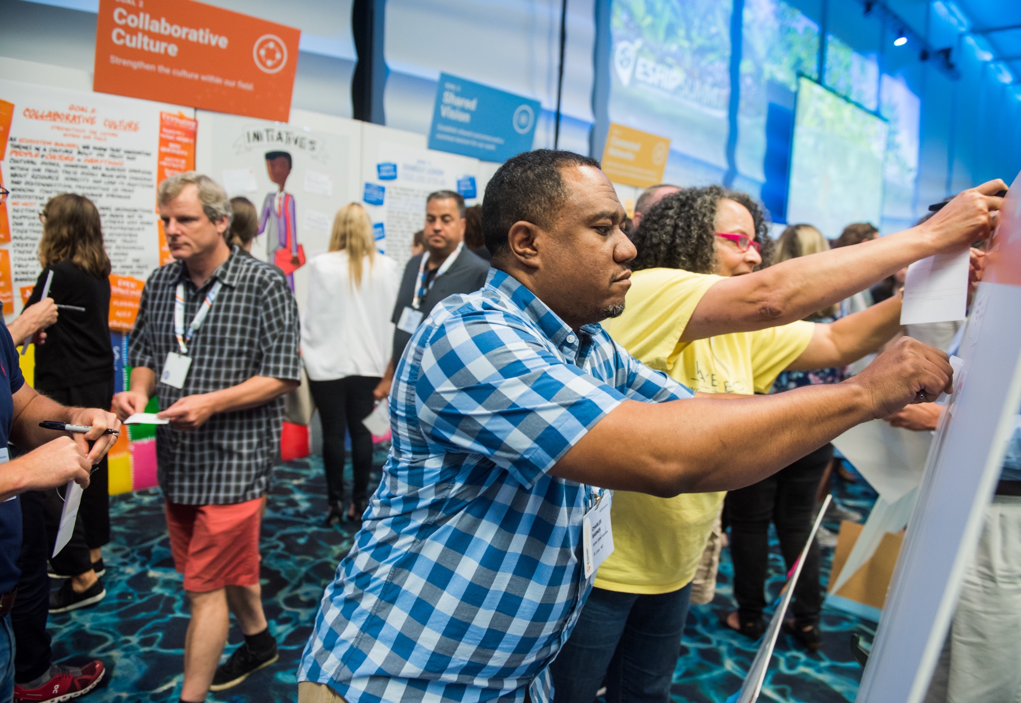 Participants contributing to a collaborative wall activity